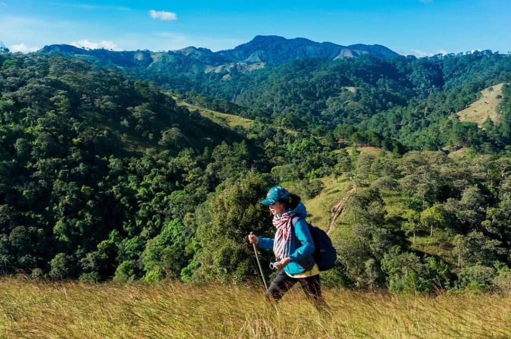 bạn nữ dùng gậy hỗ trợ trekking qua con dốc
